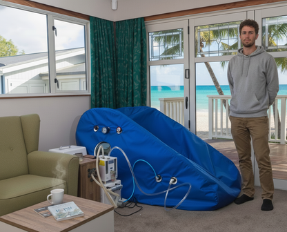 Man standing next to a large blue inflatable slide in a living room with a beach view.